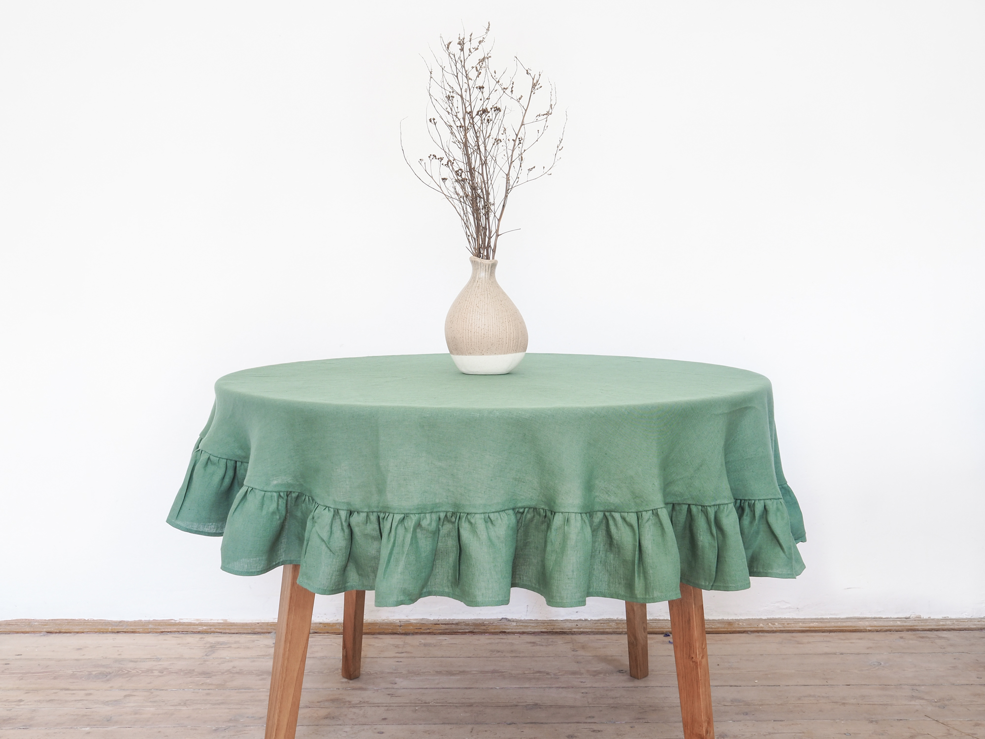 Green linen tablecloth with a frill